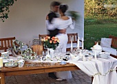 Wedding table with gifts, bride and groom dancing