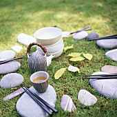Still life with tea, chopsticks and stones in the open air