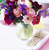 Vase of flowers on table with forks