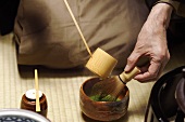 Tea master at tea ceremony, pouring water onto tea