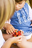 Kinder halten Erdbeeren in der Hand