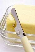 Butter in a glass butter dish with a butter knife