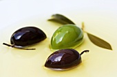 Drei Oliven mit Blätter in Öl
