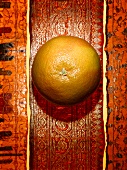 Eine Grapefruit auf orientalischem Untergrund
