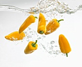 Pointed peppers falling into water