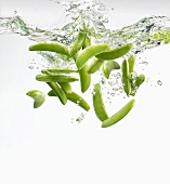Sugar snap peas falling into water