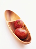 Two pomegranates in a wooden bowl