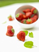 Strawberries in and in front of a small bowl