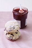 Two cranberry scones and jar of strawberry jam