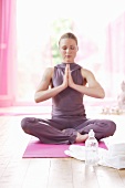 Woman in lotus position with bottle of water