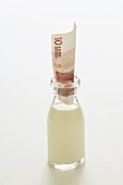 Flasche Milch mit 10-Euro-Geldschein