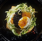 Bread topped with boiled egg, caviar and sprouts