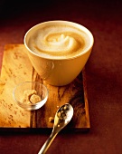 Milchkaffee in einer Schale mit braunem Zucker