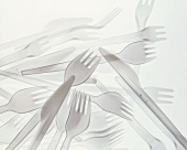 Plastic knives and forks on sheet of glass