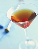 A glass of Manhattan with a cocktail cherry