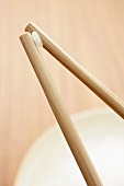 Grain of rice held between chopsticks