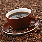 A cup of coffee on coffee beans