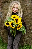 Blondes Mädchen mit Sonnenblumen