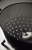 An apple in a colander