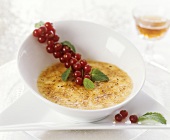 Crème brûlée in small bowl with redcurrants