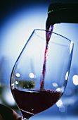 Rotwein wird ins Glas gegossen