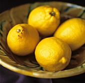 Four lemons in a bowl