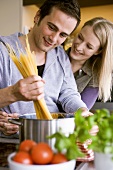 Young couple cooking spaghetti together