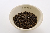 Black peppercorns in a small dish