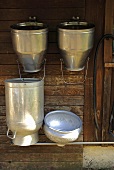Milchkannen an der Wand einer Holzhütte