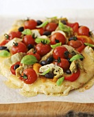 Pizza topped with tomatoes, olives and artichokes