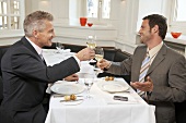 Two men drinking a glass of white wine together