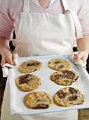 Woman holding a tray of freshly baked biscuits