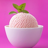 A scoop of strawberry ice cream in a white bowl