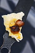 Pieces of fried chorizo with bread on a pan handle
