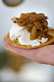 Soft cheese and onion relish on a cracker (UK)