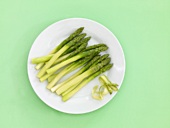Peeled green asparagus on a china plate