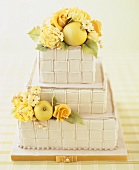 Three-tiered cake with basket-weave effect, flowers and apples