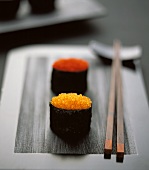 Gunkan maki with two sorts of caviare on black platter