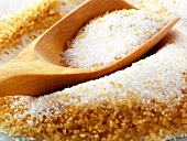 Weisser und brauner Zucker mit Holzschaufel
