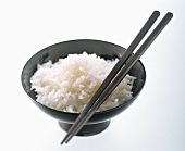Schale gekochter Reis mit Essstäbchen