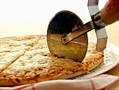 Käsepizza mit Pizzaschneider anschneiden