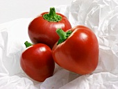 Three Red Cherry Peppers on White Paper