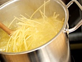 Spaghetti Boiling in a Stock Pot with Wooden Spoon