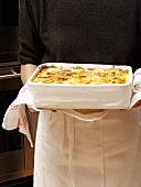 A Pan of Lasagna Being Held