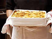 A Pan of Lasagna Being Held
