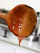 Cherry Sauce Dripping from a Wooden Spoon