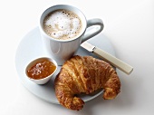 Croissant with marmalade and a cup of coffee