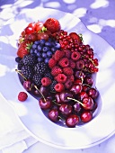 Fresh berries and cherries on a white plate