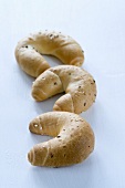 Three cresent-shaped rolls with salt and caraway