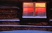 Fenster von Blockhaus im Schnee
